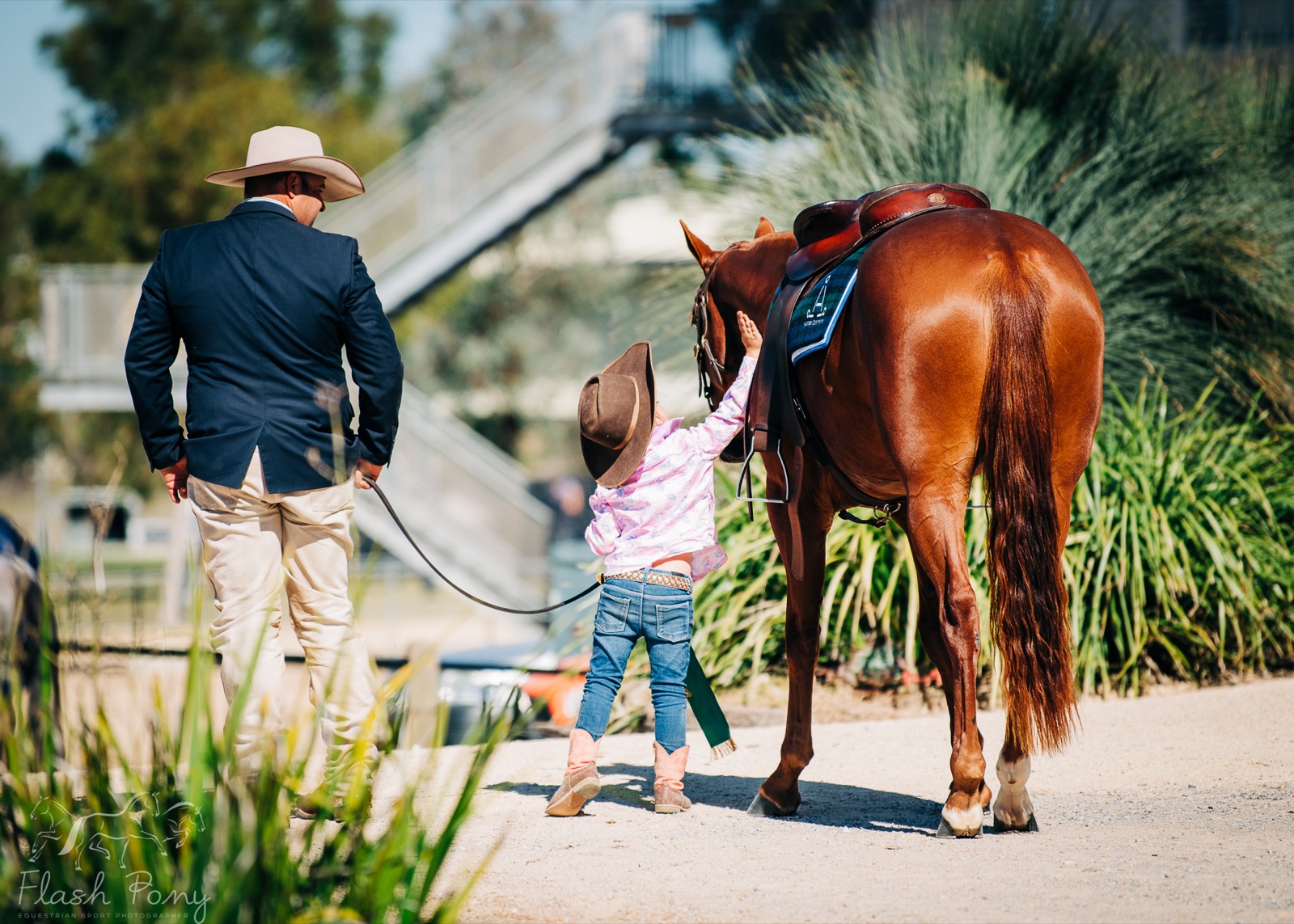 Father and daughter walking with horse