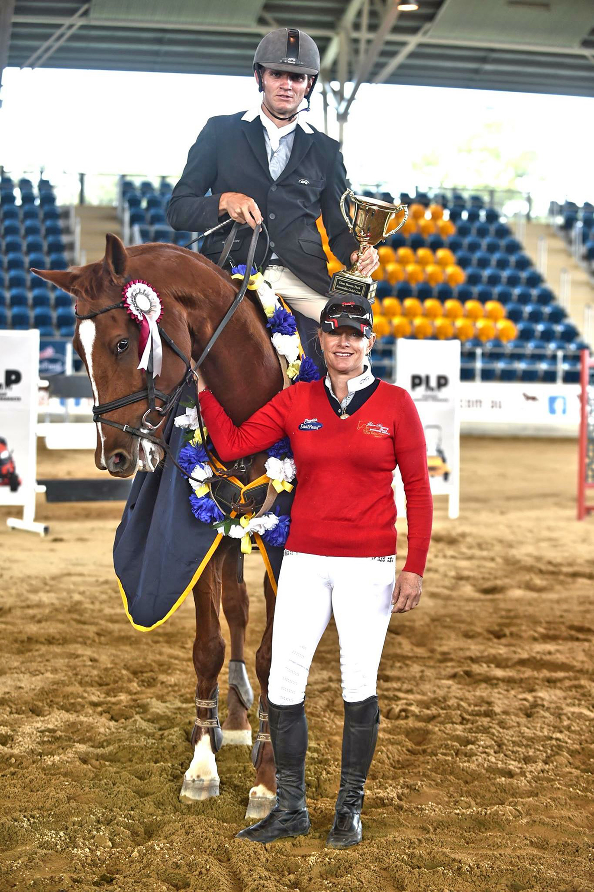 Couple at showjumping event with trophy.
